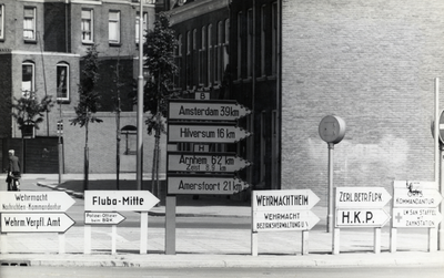 97543 Afbeelding van een wegwijzer en Duitstalige richtingborden langs de toegangsweg tot de Leidseveertunnel te ...